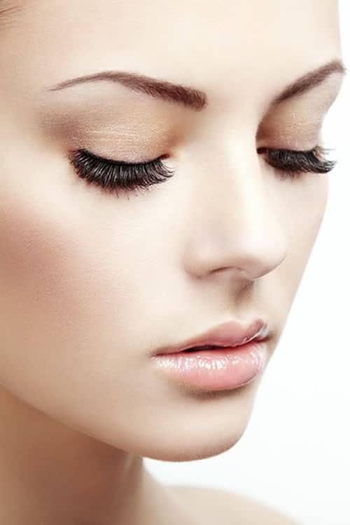 A model with closed eyes and a smooth, straight nose, photographed against white