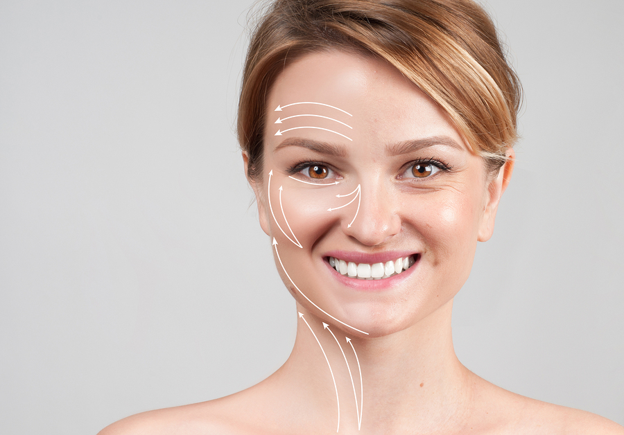 A smiling woman with white guide lines drawn over her face and neck